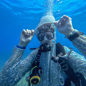 Person scuba diving underwater with bubbles and equipment.