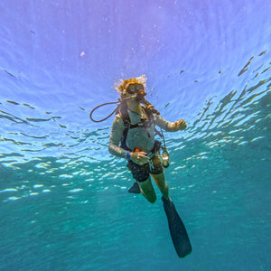 Diver underwater with clear blue water and sunlight