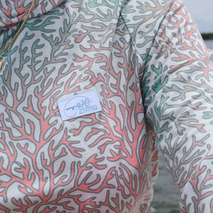 Close-up of a shirt with coral pattern and brand label, blurred background