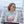 Woman on a boat wearing sunglasses with a scenic background