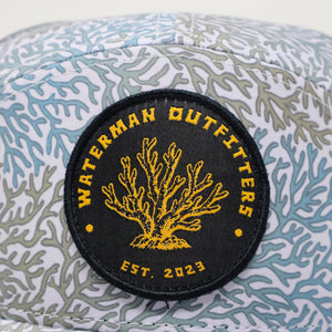 Cap with coral pattern and Waterman Outfitters logo on a white background