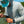 Person fly fishing by a body of water with trees in the background