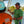 Two men on a boat, one wearing a green shirt and sunglasses, the other in an orange shirt with palm tree design.