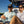 Two people sitting on a boat, smiling and wearing sunglasses.
