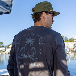 Man wearing a long-sleeve shirt with a palm tree design on a boat