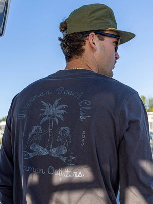 Man wearing a long-sleeve shirt with a palm tree design on a boat